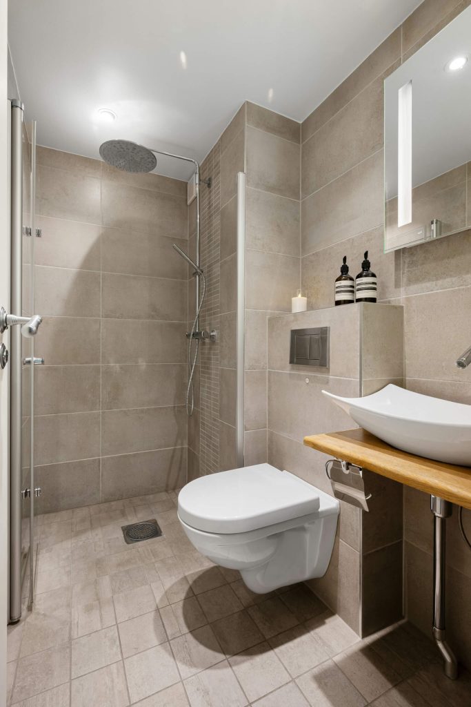 Contemporary accessible bathroom with curbless shower, wall-mounted toilet, and shower seating